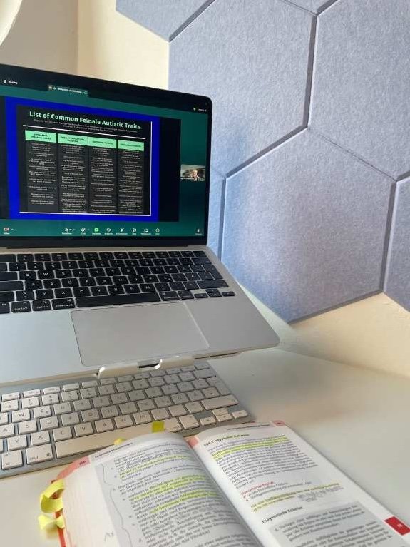 geöffneter ICD-1-10 und Laptop mit Fortbildung zu Autismus